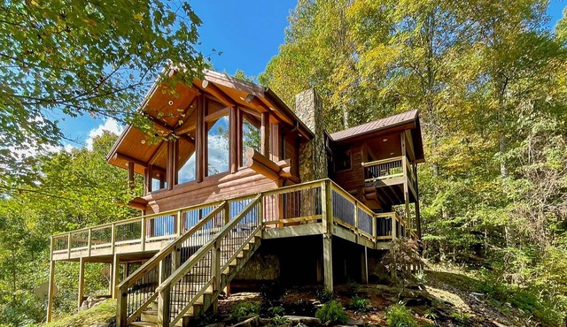 Secluded log cabin with fireplace and hot tub on deck.